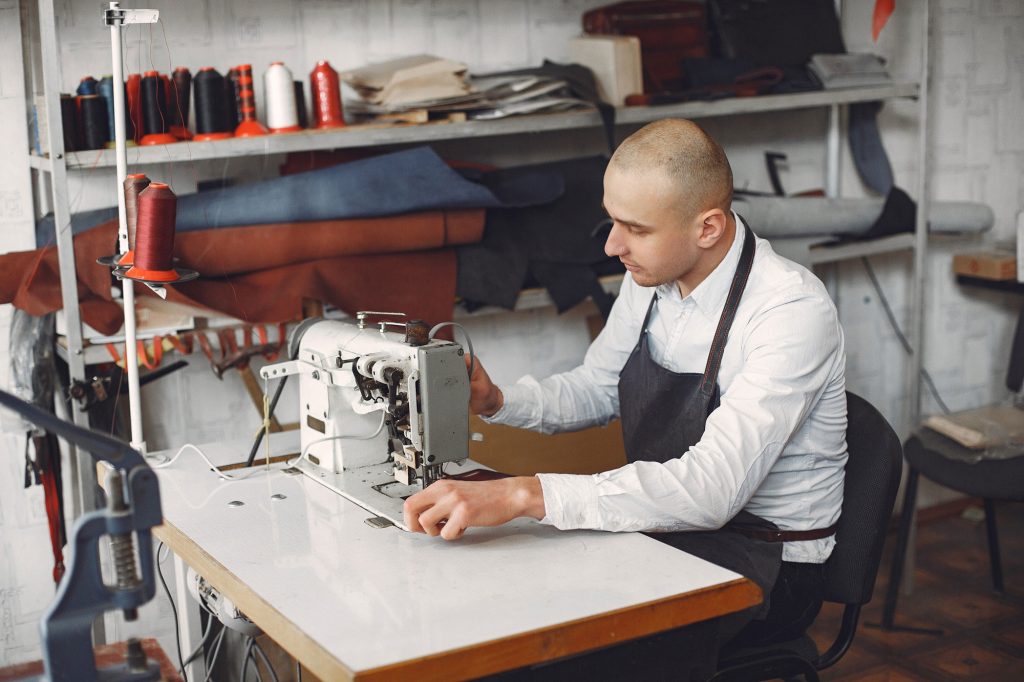A man sewing a clothe